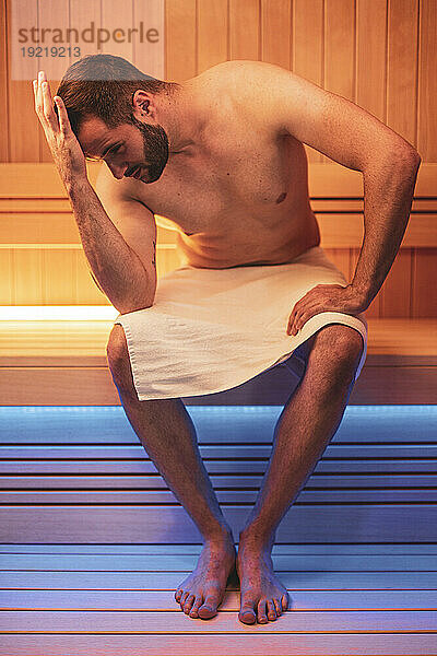 Junger bärtiger Mann in der Sauna