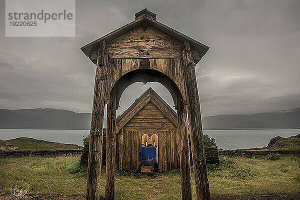 Holzbögen und Gebäude der nachgebauten Tjodhilde-Kirche im grönländischen Brattahlid  Eriksfjord-Gebiet  Teil einer Rekonstruktion der Siedlung von Erik dem Roten  Weltkulturerbe Kujataa  Qassiarsuk; Südgrönland  Grönland