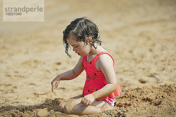 Junges Mädchen genießt das Spielen im Sand am Kamaole Beach; Maui  Hawaii  Vereinigte Staaten von Amerika