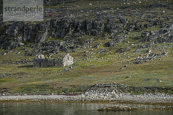 Reisegruppe erkundet die archäologische Stätte Hvalsey in der Nähe von Qaqortoq  wo sich an der Südspitze Grönlands eine antike Ruine einer Kirche aus dem Jahr 1300 n. Chr. befindet; Südgrönland  Grönland