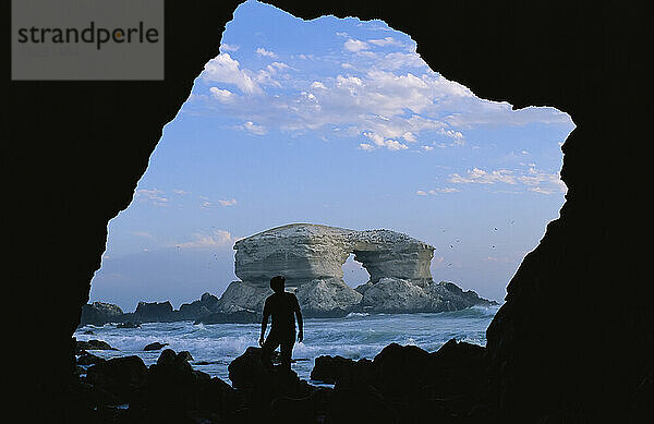 Silhouette eines Mannes vor dem Felsbogen La Portada an der Küste Chiles; La Portada  Antofagasta  Chile