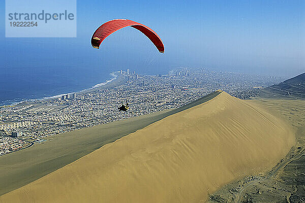 Gleitschirmfliegen über der Sanddüne Cerro Dragon und der Küstenstadt Iquique  Chile am Rande der Atacama-Wüste; Chile