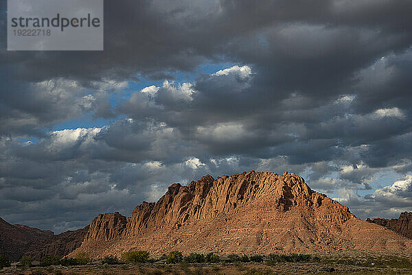 Wanderweg durch den Snow Canyon  hinter dem Red Mountain Spa im Red Cliffs Desert Reserve rund um St. George Town mit roten Felsklippen und dunklen Wolken am blauen Himmel; St. George  Utah  Vereinigte Staaten von Amerika