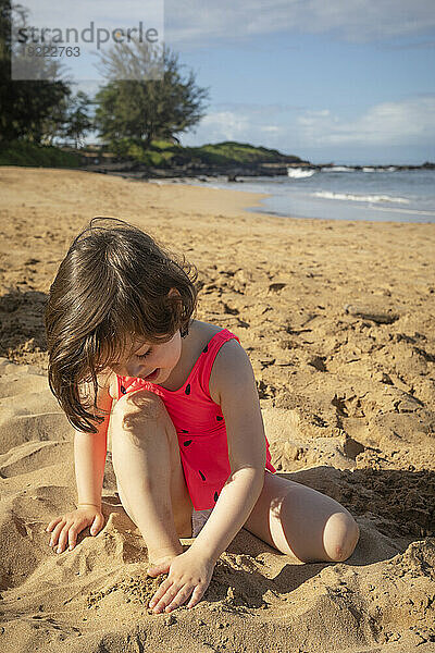 Junges Mädchen genießt das Spielen im Sand am Kamaole Beach; Maui  Hawaii  Vereinigte Staaten von Amerika