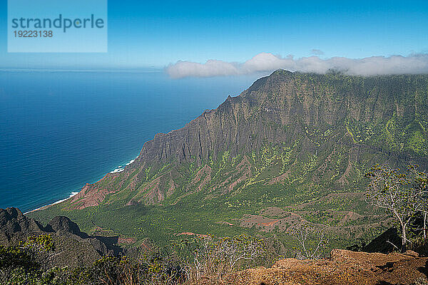 Malerische Aussicht auf die grün bedeckten Bergklippen der Napali-Küste entlang des Kalalau Trail auf der hawaiianischen Insel Kauai vor dem ruhigen blauen Wasser des Pazifischen Ozeans; Kauai  Hawaii  Vereinigte Staaten von Amerika