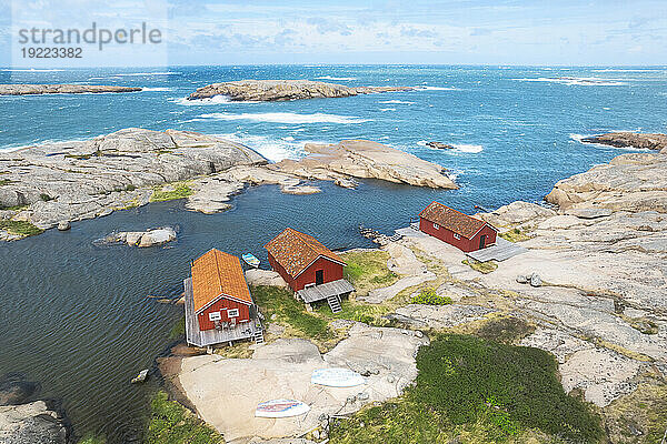 Einsame rote Holzhütten an einer felsigen Küste  Bohuslän  Västra Götaland  Westschweden  Skandinavien  Europa