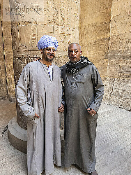 Zwei ägyptische Männer stehen im Tempelkomplex von Philae  dem Tempel der Isis  derzeit auf der Insel Agilkia  Ägypten  Nordafrika  Afrika