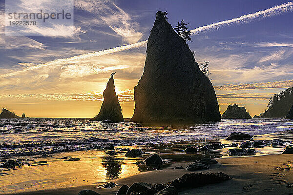 Golden sunset on Rialto Beach with sun behind the iconic rock formations  Washington State  United States of America  North America