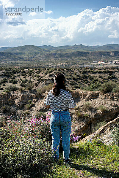 Junge Frau blickt an einem sonnigen Tag auf die Wüste von Tabernas  Almeria  Andalusien  Spanien  Europa