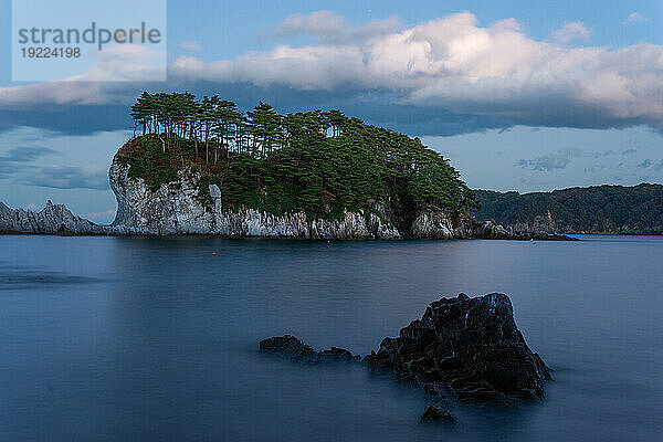 Long exposure of seascape with white cliff island with trees in distance  Jodogahama  Iwate prefecture  Japan  Asia