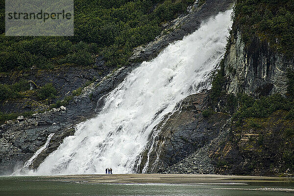 Touristen an den Nugget Creek Falls  die in den Mendenhall Lake stürzen; Juneau  Alaska  Vereinigte Staaten von Amerika