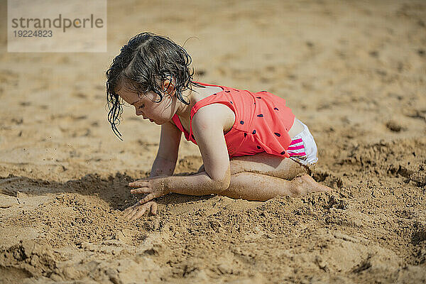 Junges Mädchen genießt das Spielen im Sand am Kamaole Beach; Maui  Hawaii  Vereinigte Staaten von Amerika