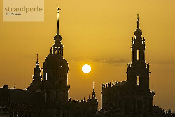 Sonnenuntergan in Dresden. Die Sonnenscheibe  durch den Saharastaub  besonders orange eingefäbt  geht hinter der Silhouette der Dresdner Altstadt unter