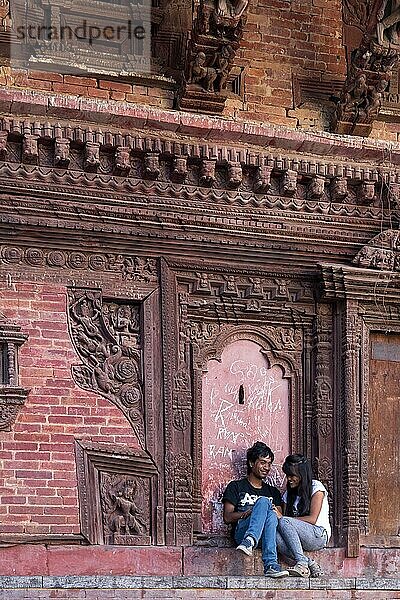Kathmandu  Nepal  19. Oktober 2014: Ein glückliches junges Paar sitzt und spricht vor einem Tempel auf dem Durbar Sqaure  Asien