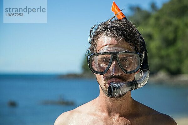 Dunk Island  Australien: Ein junger Mann mit Schnorchelausrüstung an einem Strand auf Dunk Island