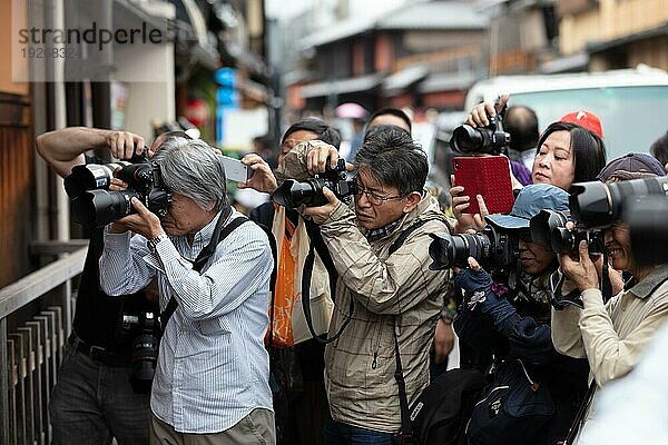 Paparazzi und Touristen verfolgen eine Geisha im Stadtteil Gion in Kyoto  Kyoto  Japan  Asien