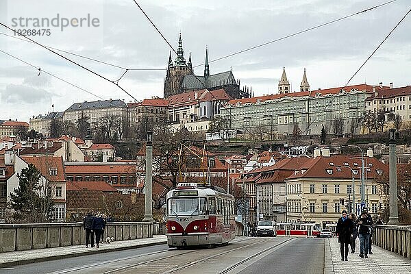 Prag  Tschechische Republik  20. März 2017: Eine rote Straßenbahn und Menschen auf einer Brücke mit der Prager Burg im Hintergrund  Europa