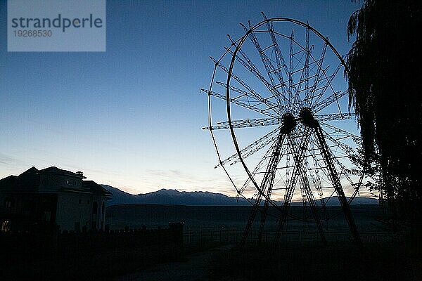 Eine Silhouette eines alten  verlassenen Riesenrads in Toktogul  Kirgisistan