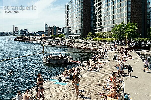 Kopenhagen  Dänemark  30. Juni 2022: Menschen genießen die Sonne an der Kalvebod Welle  einer Holzpromenade am Hafenufer  Europa