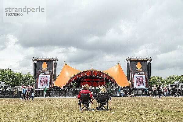 Roskilde  Dänemark  1. Juli 2016: Zwei Menschen sitzen vor der orangefarbenen Bühne beim Roskilde Festival 2016  Europa