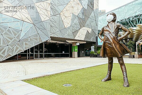 Melbourne  Australien  4. Oktober 2020: Der Federation Square und eine maskierte Statue des Fearless Girl in Melbourne sind während der Coronaviruspandemie und der damit verbundenen Abriegelung ruhig und leer  Ozeanien