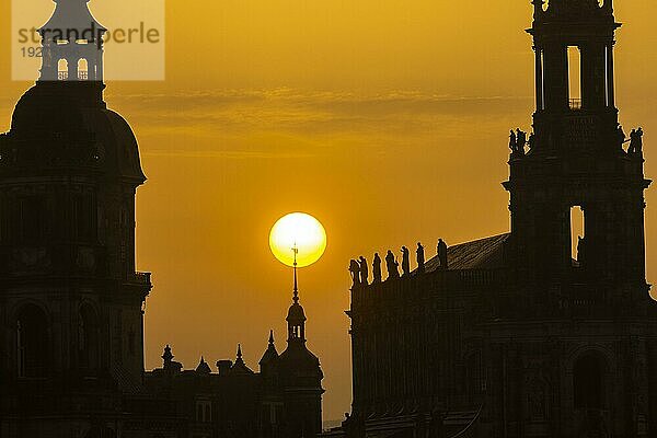 Sonnenuntergan in Dresden. Die Sonnenscheibe  durch den Saharastaub  besonders orange eingefäbt  geht hinter der Silhouette der Dresdner Altstadt unter