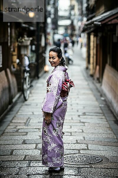 Junge Frau in einem Kimono in den Straßen von Kyoto an einem warmen Frühlingstag  Kyoto  Japan  Asien