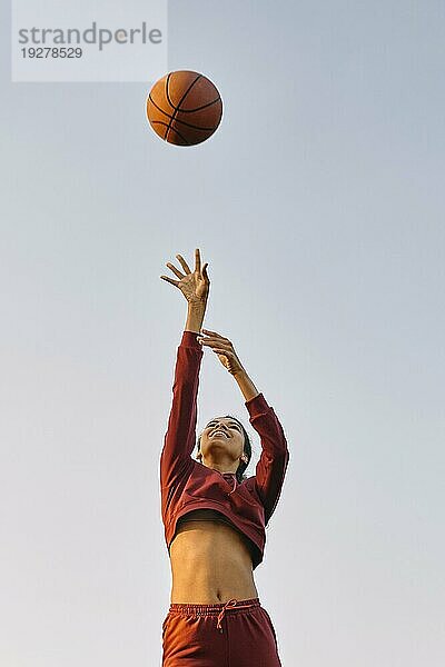 Junge Frau spielt Basketball