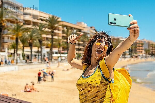 Ein junger Tourist macht ein Selfie mit seinem Handy am Playa del Cura in der Küstenstadt Torrevieja  Alicante  Valencianische Gemeinschaft. Spanien  Mittelmeer