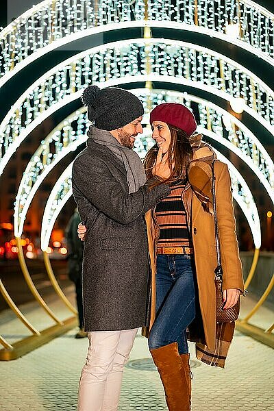 Romantischer Winterblick eines kaukasischen Paares neben der Weihnachtsbeleuchtung der Stadt  Lifestyle
