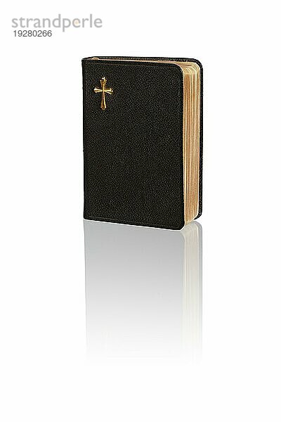 Eine kleine Vintage Bibel auf weißer spiegelnder Oberfläche