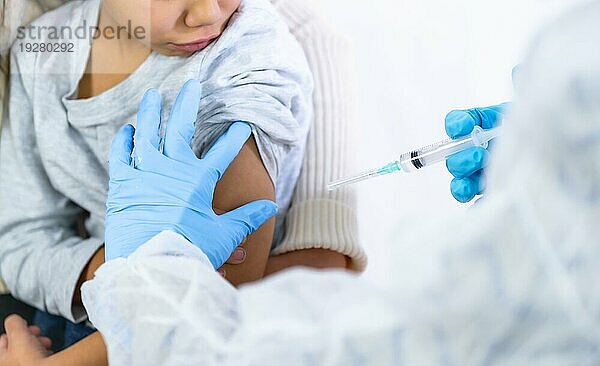 Eine Ärztin injiziert einem Kind mit seiner Mutter den Impfstoff. Impfung von Kindern zur Immunisierung gegen die Coronaviruspandemie Covid19