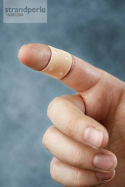 Ein Finger mit einem Textilklebeverband. Kurze Tiefenschärfe