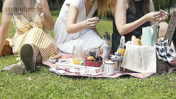 Close up Frauen sitzen grünes Gras genießen Picknick