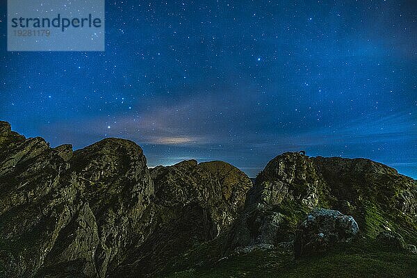 Silhouette eines jungen Mannes bei Nacht auf dem Berg Aiako Harria in Oiartzun. Baskenland