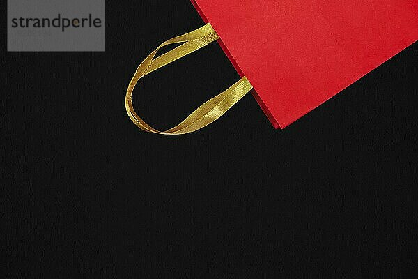 Rote Einkaufstasche auf dunklem Hintergrund. Kauf  Liebe  Valentinstag  Verkauf  Black Friday Konzept. Ansicht von oben  Kopie Raum