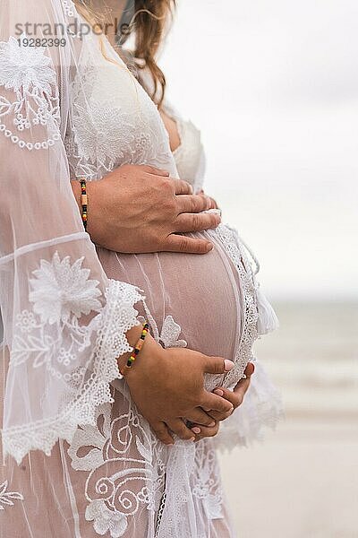 Silhouette einer schwangeren Frau in einem weißen Kleid am Strand  schwanger Sitzung einer neuen Schwangerschaft