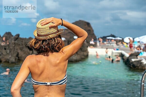 Der Badeort Porto Moniz  ein junges Touristenmädchen mit Hut und Bikini an den natürlichen Pools  Madeira