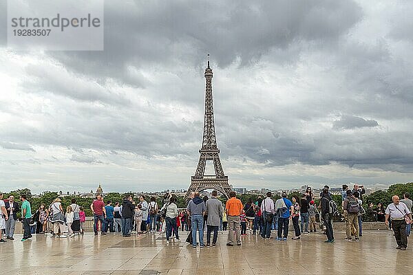 Paris  Frankreich  12. Mai 2017: Menschen auf dem Trocadero Platz mit dem berühmten Eiffelturm im Hintergrund an einem bewölkten Tag  Europa
