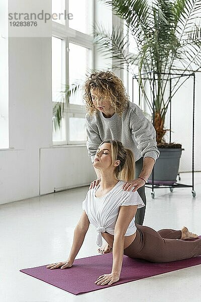 Yogalehrer hilft Frau