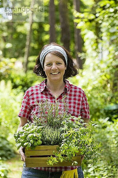 Frau mit Kräutern im Garten  woman with herbs in a garden