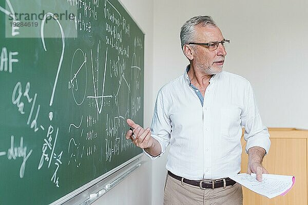 Älterer Mathelehrer erklärt Formel im Klassenzimmer