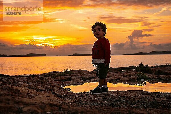 Sonnenuntergang auf Ibiza im Urlaub  ein einjähriger Junge hat Spaß am Meer in San Antonio Abad