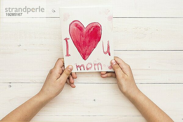 Person hält Papier mit Ich liebe dich Mama Inschrift