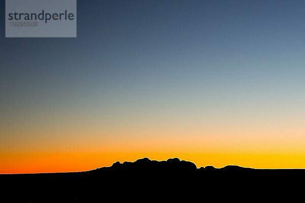 Die Silhouette der Felsblöcke der Olgas bei Sonnenuntergang an einem klaren Winterabend im Northern Territory  Australien  Ozeanien