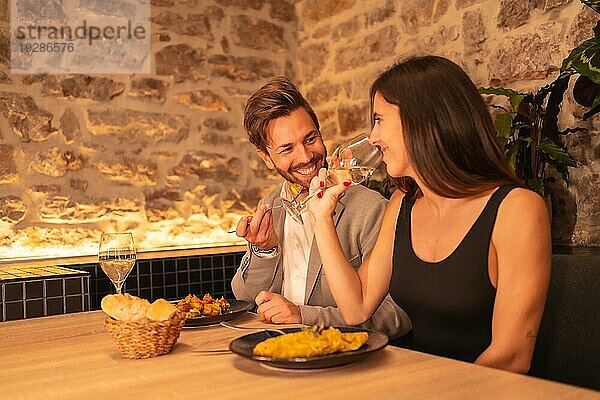 Lifestyle  ein hübsches  verliebtes junges Paar in einem Restaurant  das gemeinsam zu Abend isst und den Valentinstag feiert