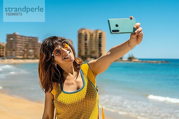 Ein junger ausländischer Tourist mit dem Telefon in Playa del Cura in der Küstenstadt Torrevieja  Alicante  Valencianische Gemeinschaft. Spanien  Mittelmeer