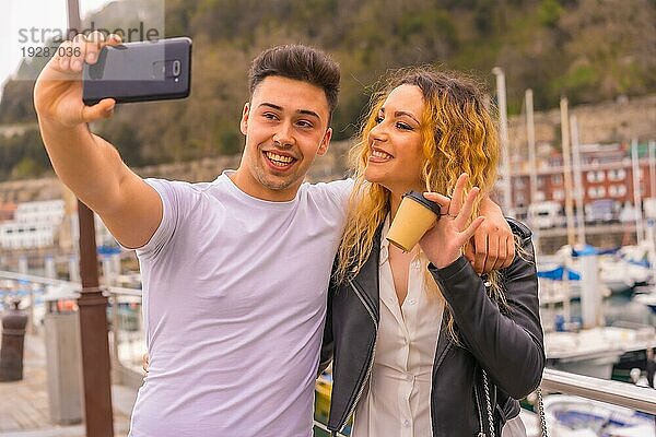 Lebensstil eines Paares beim Sightseeing und beim Genießen der Ferien. Schlendern durch eine Hafenstadt und Fotografieren