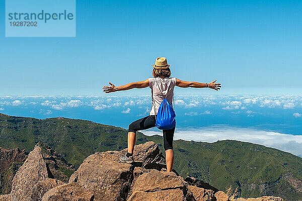 Eine junge Frau genießt die Freiheit am Miradouro do Juncal auf dem Pico do Arieiro  Madeira. Portugal