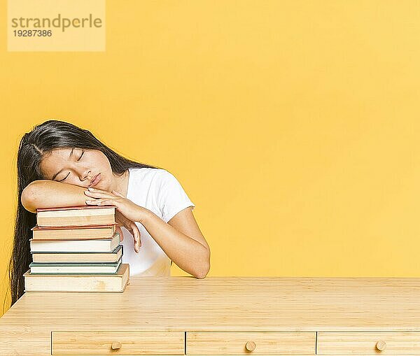 Stapel Bücher Schreibtisch Frau schlafend